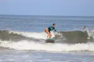 Beginner learning to surf in Tamarindo Costa Rica with instructor